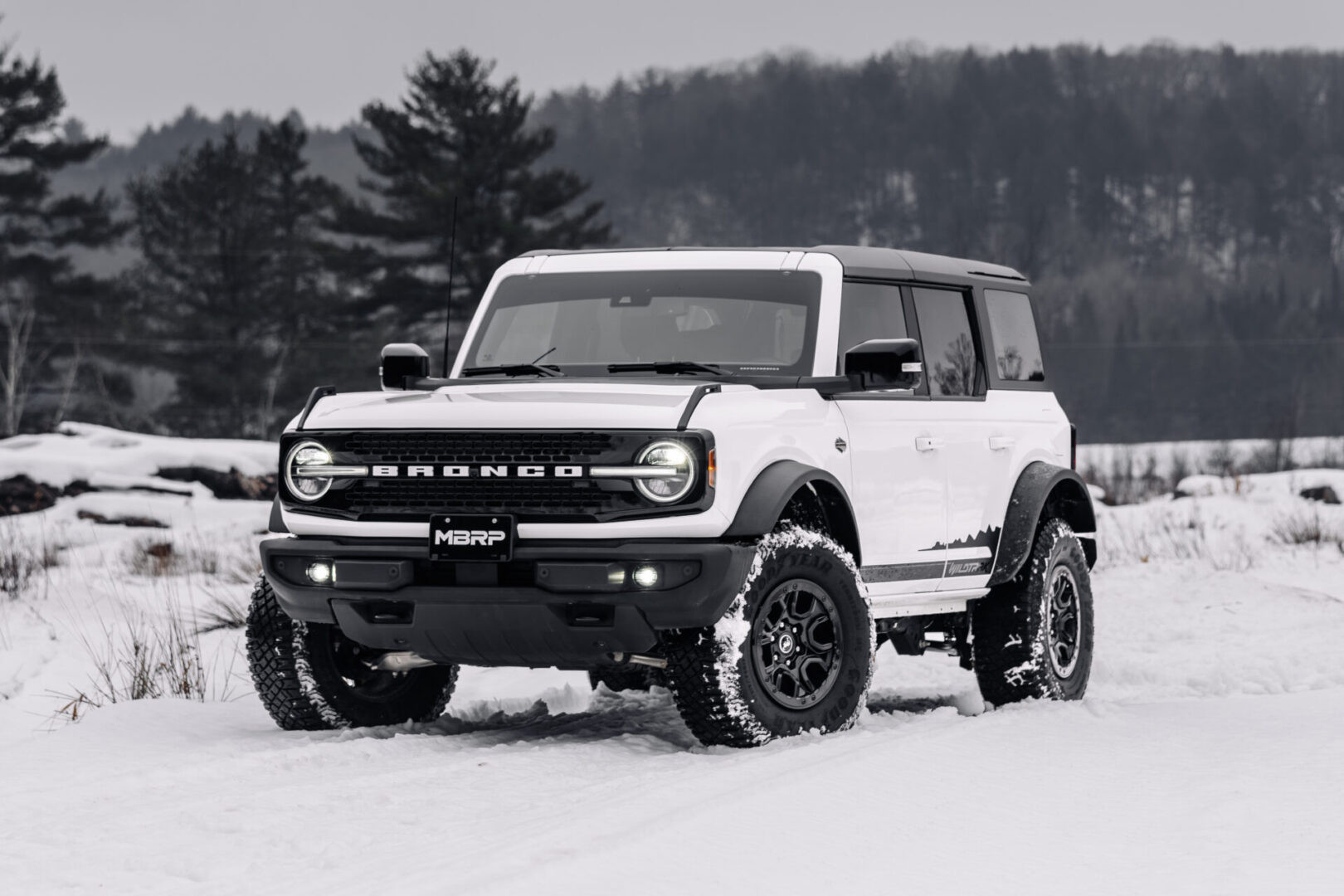 The 2019 Ford Bronco is driving down an off-road snowy road.