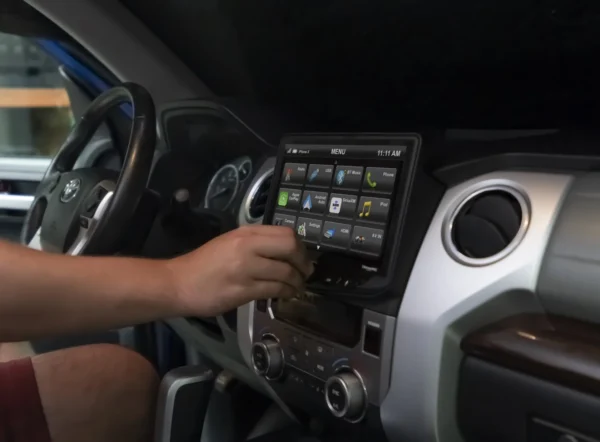 A person using a Toyota Tundra (2014-2021) HEIGH10 10" Touch Screen Radio Plug-and-Play Kit in a car.